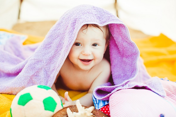 À quel âge pouvez-vous obtenir un diagnostic d'autisme pour votre enfant? Petit garçon couché avec une serviette violette