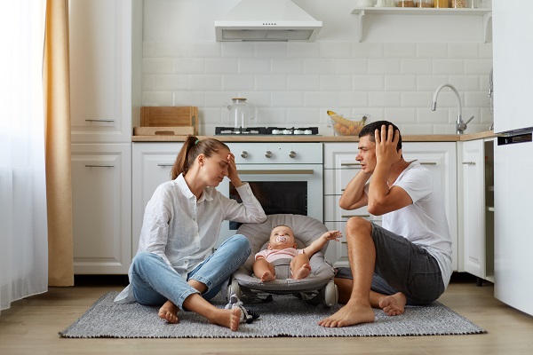 Conseils aux parents fatigués, père, mère et bébé assise au sol du cuisine