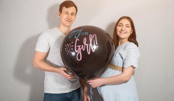 Dans l'attente de la grande révélation: photo d'un couple tenant un ballon noir