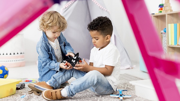 Apprendre aux enfants à partager, deux garçons jouent ensemble sur le tapis