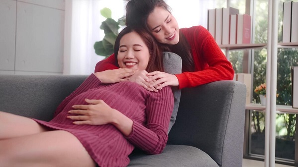 La FIV réciproque pour les couples LGBTQ: photo de 2 femmes en pull rouge et grenat.