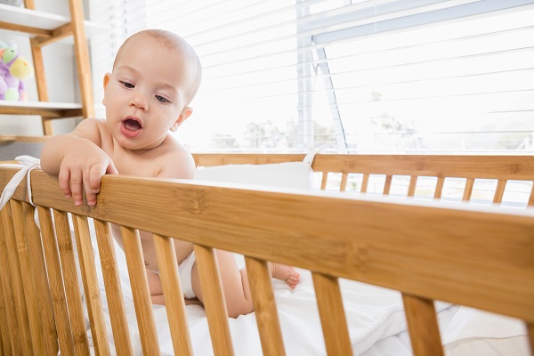 La sécurité des nourrissons et le SMSN, bébé joue dans le berceau