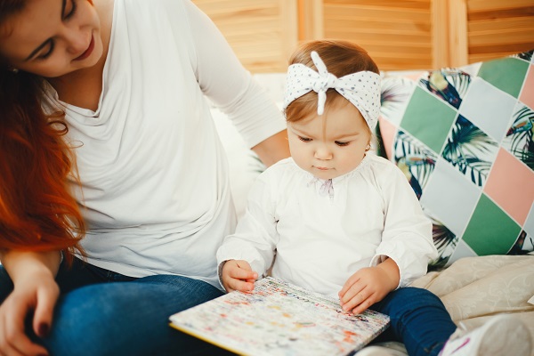 Les signes de l'autisme : Votre guide mois par mois, mère et petite fille sur le lit