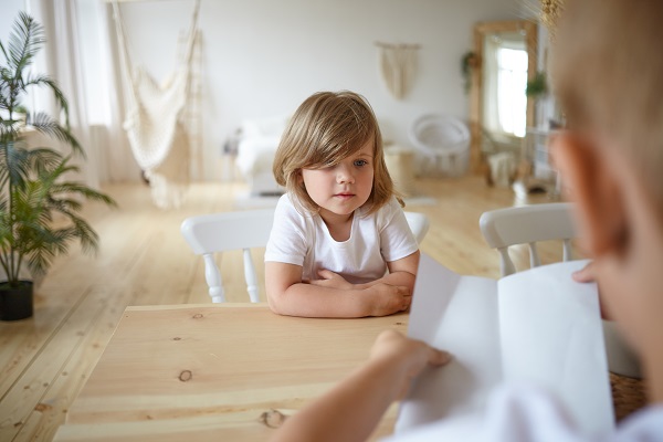 Obtenir un premier diagnostic d'autisme : Guide complet, petite fille assise à une table