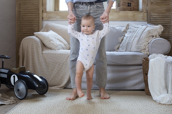 Pourquoi mon enfant n'atteint-il pas les étapes importantes de sa vie ? Bébé qui marche avec un parent, de près