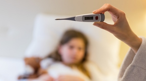 Signes de fièvre chez les bébés et les enfants: photo d'une main tenant un thermomètre.