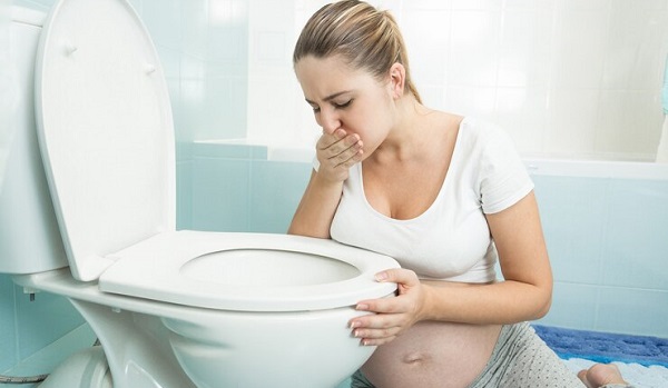 Survivre aux aversions alimentaires pendant la grossesse: photo d'une femme enceinte en train de vomir au toilette.