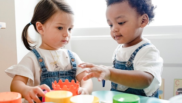 signaler un trouble de l'apprentissage : photo d'une petite fille et d'un petit garçon en chemises blanches et salopettes jeans.