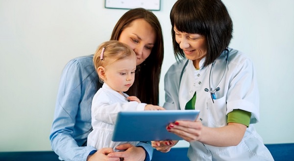 mis à jour des étapes du développement de l'enfant : photo enfant en regardant une tablette avec sa maman et un medecin