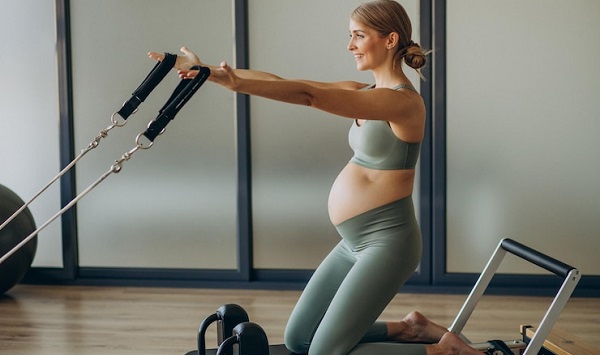 Nos meilleures séances d'entraînement à essayer pendant la grossesse: photo d'une femme enceinte en leggings sport gris.