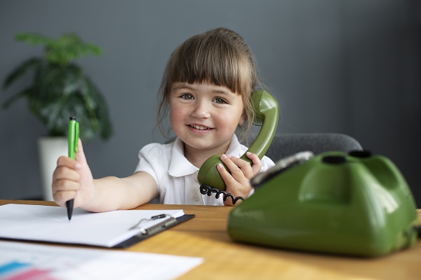 développement du langage et les retards de paroles chez l'enfant: enfant tient téléphone,